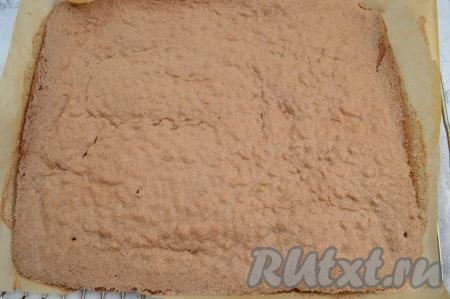 Духовку заранее разогреть до 180 градусов, затем поставить в неё противень с шоколадным тестом. Выпекать минут 12-14 (до готовности) при температуре 180 градусов. Готовность выпечки легко проверить, проколов корж сухой зубочисткой, если бисквит уже готов, значит зубочистка после прокола останется чистой и сухой. Важно не пересушить шоколадный бисквит в духовке. Достать противень из духовки. Переложить корж с противня на стол.