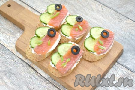 Украшаем брускетты на своё усмотрение. Я украсила маслинами, нарезанными на кружочки, и мелко нарезанной зеленью (у меня - перья зелёного лука).