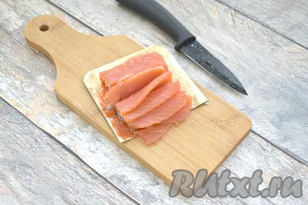 Слабосолёную красную рыбу нарезаем на тонкие пластинки.