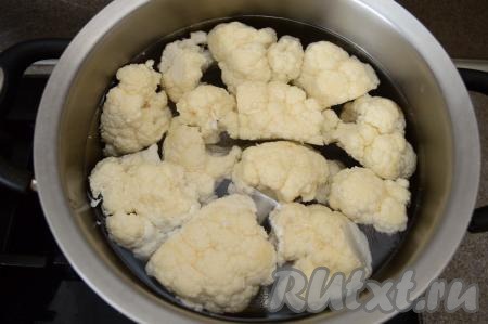 Соцветия цветной капусту выложить в кастрюлю, полностью залить водой и поставить на огонь. После закипания, подсолив воду, варить цветную капусту минут 6-7 на небольшом огне. Отваренные соцветия капусты должны прокалываться ножом практически без усилий. В зависимости от сорта цветная капуста может вариться различное время, так что лучше проверяйте готовность ножом. Цветную капусту не нужно переваривать, она становится очень мягкой и перестаёт держать форму (разваливается). Затем оду из кастрюли слить, дать варёным соцветиям остыть. 