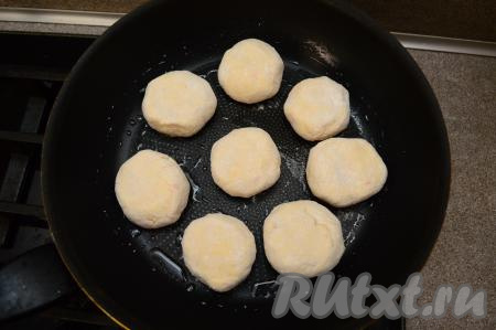Сковороду хорошо разогрейте с растительным маслом. Сделайте огонь средним. На сковороду выложите заготовки сырников. Жарьте сырники 2-3 минуты (до подрумянивания снизу).