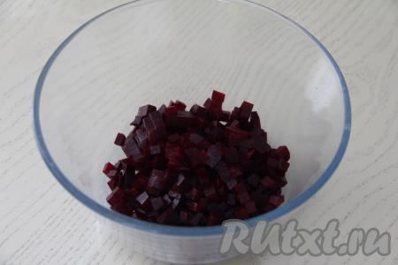 Свеклу почистить и нарезать на кубики размером 1 сантиметр на 1 сантиметр, выложить в объёмный салатник.