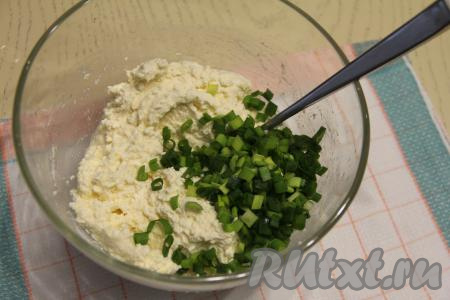 Творожное тесто для сырников перемешать вилкой (или столовой ложкой). Добавить мелко нарезанный зелёный лук, снова перемешать.