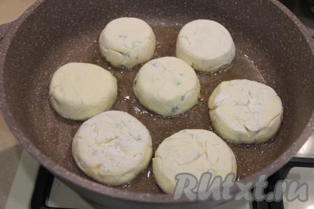В сковороду влить растительное масло, хорошо прогреть. Сделать огонь средним. Выложить сырники с зелёным луком в сковороду.