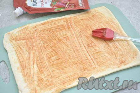 С помощью силиконовой кисточки смазываем раскатанное тесто кетчупом (или томатным соусом), немного отступив от краёв теста.
