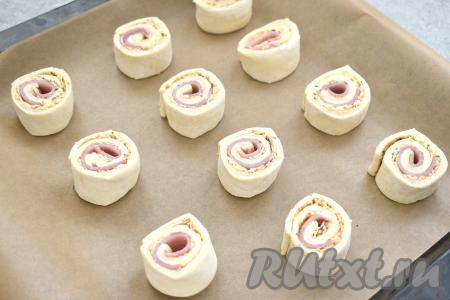 На противень, застеленный пергаментом, выкладываем рулетики срезом вверх.