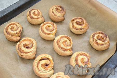 Ставим противень в разогретую до 200 градусов духовку, выпекаем рулетики с ветчиной и сыром 15-20 минут (до подрумянивания слоёного теста).