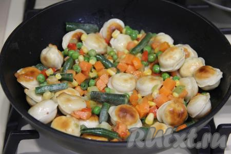 Посолить по вкусу, перемешать. Обжаривать овощи с пельменями в течение 2-3 минут, за это время несколько раз можно аккуратно перемешать.