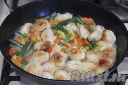 Затем влить в сковороду воду, накрыть крышкой. Дать воде закипеть, а затем тушить пельмени с мексиканской овощной смесью на небольшом огне 15 минут.