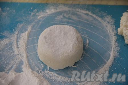 Закрыть шоколад краями творожного теста, сформировав круглый сырник. Обвалять его со всех сторон в муке. Затем сверху слегка прижать ладонью.