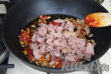 С консервированного тунца слить лишний сок. Выложить кусочки тунца в сковороду, перемешать.
