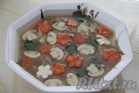 Влить в блюдо с мясом бульон, смешанный с желатином. Сверху выложить цветочки из моркови. Можно также нарезать дольками маринованные шампиньоны и тоже выложить рядом с морковкой. Заливное из куриных окорочков убрать в холодильник до полного застывания (минимум на 3 часа).