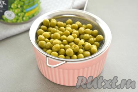 Зелёный консервированный горошек откидываем на сито, даём воде полностью стечь, а затем добавляем&nbsp; в миску с постным салатом "Оливье".