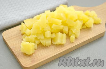 Остывшие картошку и морковку очищаем. Картофель нарезаем на маленькие кубики, складываем в миску.