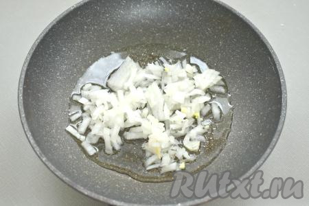 Пока варится перловка, займёмся обжариванием овощей. Лук и морковь очищаем, из болгарского перца удаляем семена. В сковороде хорошо разогреваем растительное масло, выкладываем мелко нарезанный лук, обжариваем его до мягкости (минуты 3), иногда помешивая, на среднем огне.