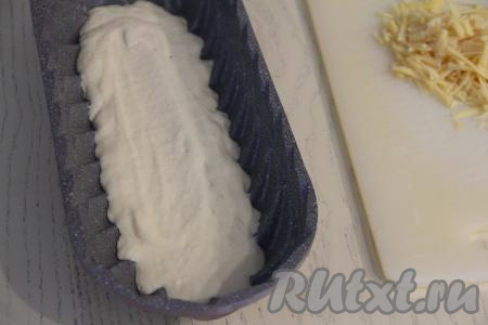 Форму для выпечки можно использовать круглую диаметром 20-22 сантиметра. Я взяла прямоугольную форму размером 32 сантиметра на 13 сантиметров. Дно и бока формы смазать растительным (или сливочным) маслом. В подготовленную форму выложить половину теста.