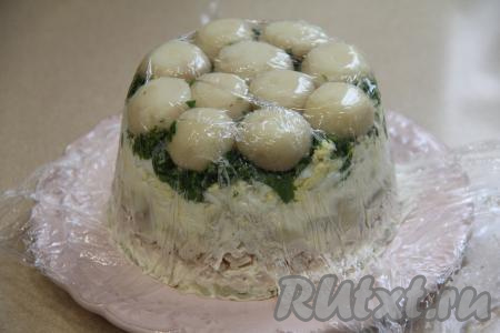 Поставить салат "Грибное лукошко" для пропитки в холодильник на 2-3 часа. Затем аккуратно развернуть края плёнки, покрывающие верх салата. Перевернуть салат на плоскую тарелку, убрать форму с плёнкой.