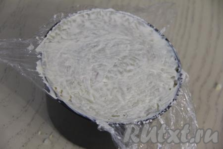 Нанести майонез и, утрамбовывая, разровнять слой. Накрыть верхний слой свисающими краями плёнки.