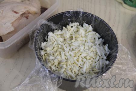 Почистить яйца, натереть их на крупной тёрке и разложить поверх зелени.