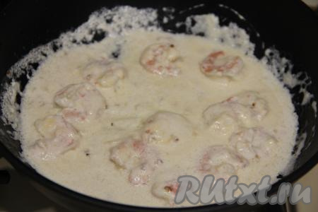 Потомить креветки в сливочном соусе до полного растворения сыра, периодически перемешивая.