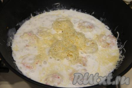 Посолить сливочный соус по вкусу, добавить в сковороду сыр, натёртый на мелкой тёрке, перемешать.