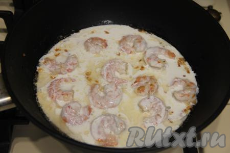 В сковороду с креветками влить сливки и на медленном огне довести соус до кипения.