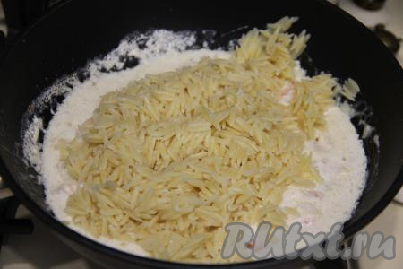 Добавить пасту "Орзо" в сковороду к сливочному соусу и креветкам, перемешать.