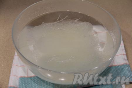 В глубокую миску выложить фунчозу, залить её кипятком и оставить на 5 минут.