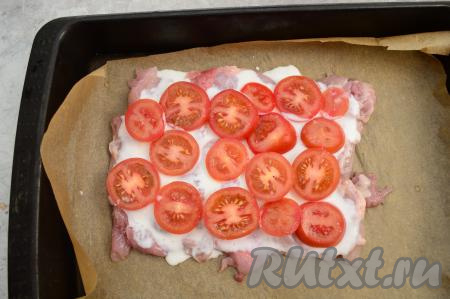 Помидоры нарезать на кружочки толщиной 5 миллиметров и разложить поверх мяса. Сверху немного помидоры присолить.