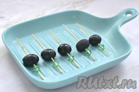 Начинаем сборку канапе. На шпажки нанизываем маслины без косточек. Кстати, вместо маслин можно взять оливки.