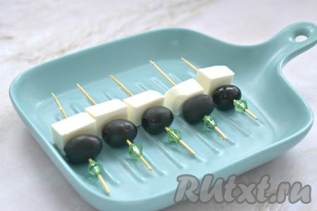 Сыр (у меня - Фетакса) нарезаем на средние кубики (ориентируемся на размер заготовок из теста). Нанизываем кусочки сыра на шпажки.