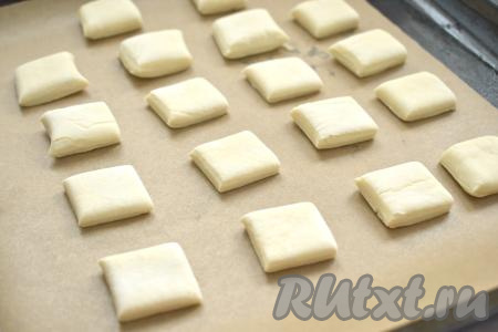 Застилаем противень пергаментом, выкладываем квадратные заготовки из теста на расстоянии друг от друга и отправляем в духовку, разогретую до 180 градусов.