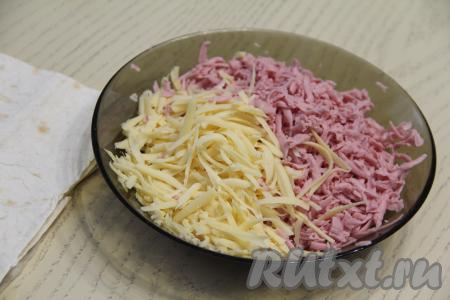 Колбасу и сыр натереть на крупной тёрке и соединить в миске.