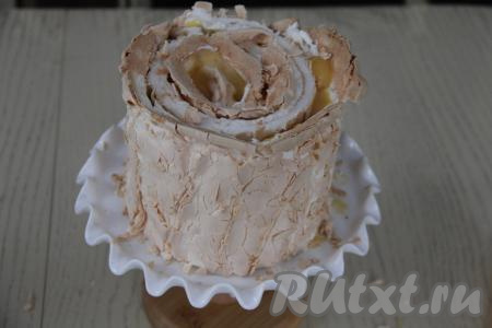 Получившийся рулетик выложить на край второй полоски. Свернуть вторую полоску вместе с этим рулетиком в один рулет (мы как бы оборачиваем вторую полоску вокруг рулетика). Аналогично поступить и с третьей полоской. В результате у нас получится торт-улитка. Поставить тортик на подставку для торта и зажать в кулинарное кольцо. Убрать в холодильник часа на 2-3.