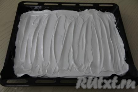 Выложить белковую массу на противень (я выпекала на противне размером 31 сантиметр на 33 сантиметра), застеленный тефлоновым ковриком для выпечки. Разровнять белковую массу лопаткой, поставить противень в хорошо разогретую духовку. Я выпекала корж на противне, застеленном тефлоновым ковриком, но можно застелить противень и силиконизированным пергаментом.