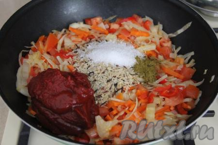 Затем добавить томатную пасту, соль и специи по вкусу, всыпать рис и влить 200 миллилитров воды комнатной температуры.