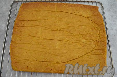 Выпекать морковный бисквит в разогретой до 180 градусов духовке в течение 20-25 минут. Готовность можно проверить, проколов бисквит сухой деревянной зубочисткой, если зубочистка после прокалывания останется сухой, значит сразу доставайте противень из духовки, не нужно пересушивать бисквит. Готовый морковный бисквит немного остудить, перевернуть с противня на решётку (или на чистую пергаментную бумагу), убрать пергамент, на которой выпекался корж. Оставить до полного остывания.