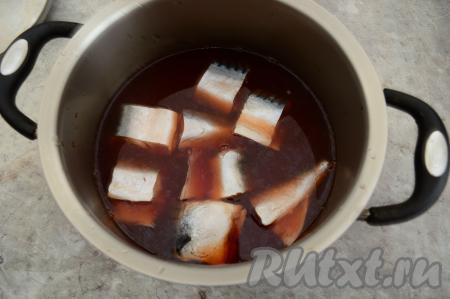 Как только рассол остынет до комнатной температуры, процедить его, удалив все специи и луковую шелуху. Выложить в кастрюлю с процеженным рассолом кусочки скумбрии, накрыть крышкой и отправить рыбку просаливаться в холодильник на 24 часа.