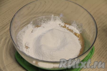 Просеять в отдельную ёмкость муку. Всыпать половину просеянной муки в миску с кофейно-дрожжевой массой, перемешать тесто лопаткой (или столовой ложкой) до однородности. Затем частями всыпать оставшуюся муку, замешивая тесто руками.