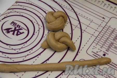 Поднявшееся тесто обмять, разделить на 8 частей. Сформировать булочки любой формы, можно просто круглые. Я каждую часть теста раскатала в жгутик длиной примерно 13 сантиметров и завязала простой узелок, затем кончики жгутика подвернула под низ кофейной булочки.