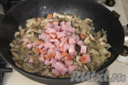 Обжаривать грибы с луком минут 15-20, чтобы вода вся выпарилась из шампиньонов, время от времени перемешивая. Ветчину нарезать на кубики и добавить в сковороду, перемешать.