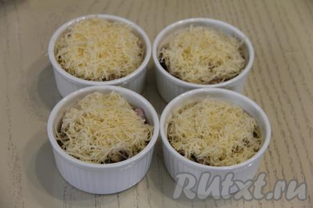 Сверху грибы с ветчиной посыпать сыром, натёртым на средней тёрке, и отправить кокотницы с жульеном в разогретую духовку.