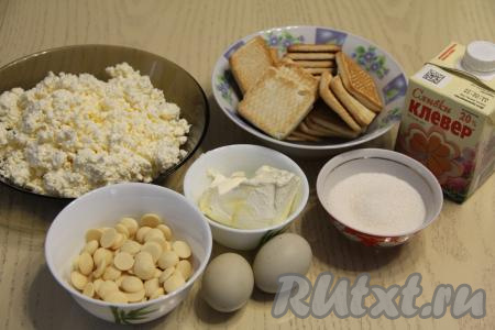 Подготовить продукты для приготовления чизкейка с белым шоколадом с выпечкой. Для этого чизкейка можно взять плитку шоколада и поломать её на кусочки или использовала шоколадные капли.