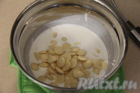 Сливки влить в сотейник, довести до кипения, снять с огня. Сразу всыпать в сливки кусочки белого шоколада (у меня были капли шоколада).