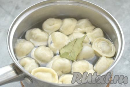 Часть пельменей я поместила в кастрюлю с кипящей подсоленной водой, добавила лавровый лист и варила на среднем огне с момента всплытия пельмешек на поверхность примерно 6-7 минут. Остальные пельмени я отправила в морозилку для заморозки, выложив их на разделочные доски в один слой. Заморозившиеся пельмени переложила в пакет и отправила в морозилку на хранение.