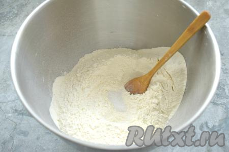 Приготовление домашних пельменей начнём с замешивания теста. Для этого в глубокую миску просеиваем 3 стакана муки, затем всыпаем соль и перемешиваем лопаткой (или ложкой), образуя в центре воронку.