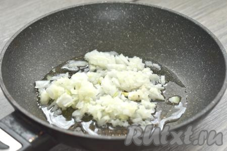 Разогреваем в глубокой сковороде растительное масло, выкладываем мелко нарезанную луковицу и обжариваем её минуты 3-4 (до мягкости) на среднем огне, иногда помешивая.