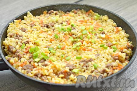 После закипания воды убавляем огонь до минимума, сковороду накрываем крышкой и готовим булгур с фаршем и овощами 15-20 минут (до испарения жидкости и готовности булгура). Убираем готовое блюдо с огня и, по желанию, посыпаем мелко нарезанной зеленью.