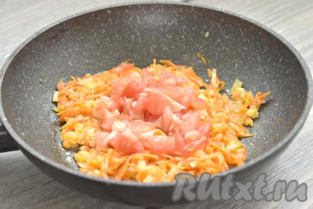 Свежий помидор, по желанию, очищаем от кожуры, затем нарезаем на небольшие кубики, добавляем к обжаренным овощам, перемешиваем. Обжариваем овощи, помешивая, минуты 3.