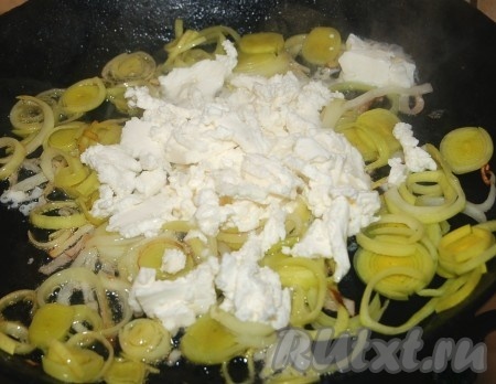 К обжаренному лука выложить фету, перемешать и обжаривать на небольшом огне, помешивая, до тех пор, пока сыр полностью не растворится.
